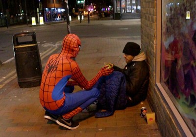 O homem-aranha anônimo distribui comida para moradores de rua