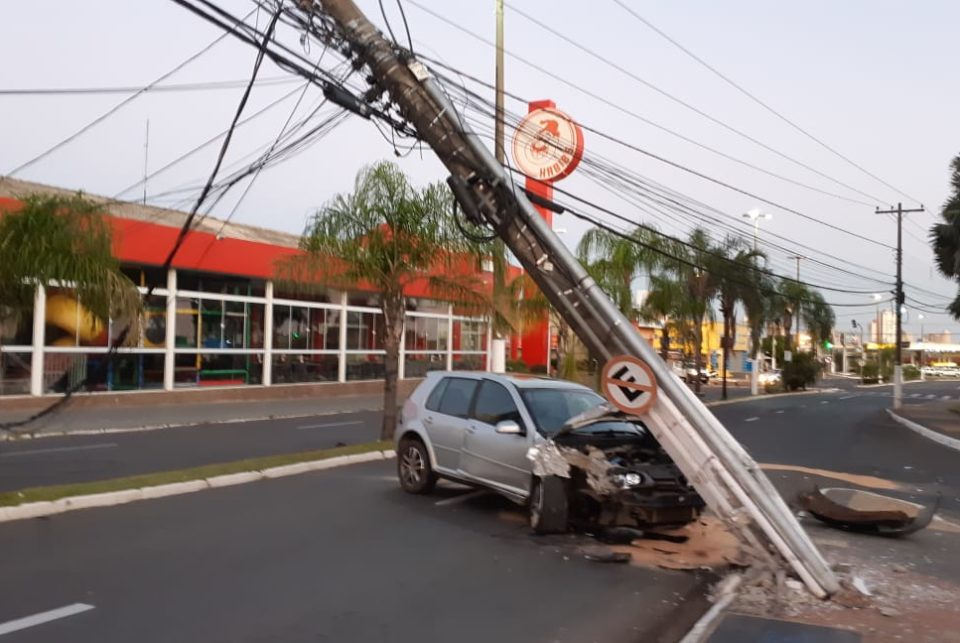 Carro bate em poste e causa acidente com motociclista