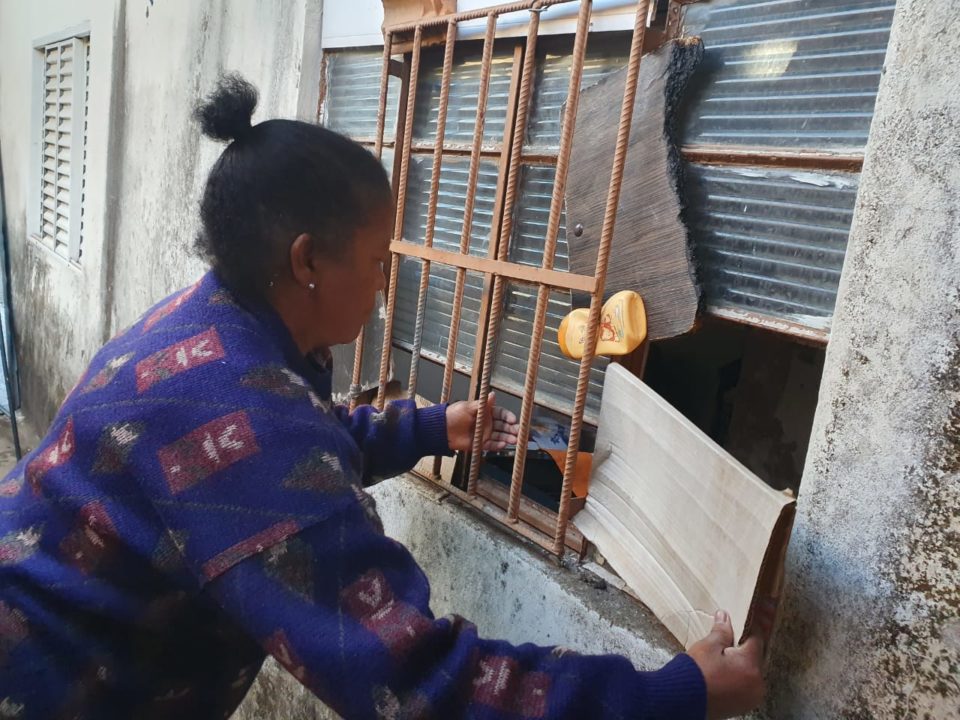 Família tapa janelas quebradas com papelão para enfrentar o frio em favela
