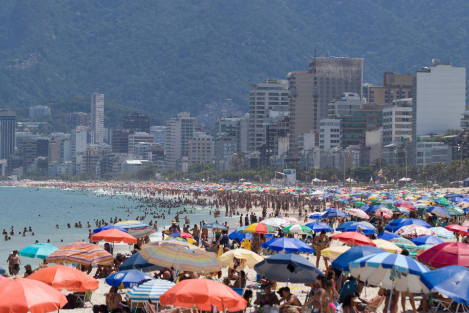 Sol e calor projetam estrada cheia e praia lotada no feriado